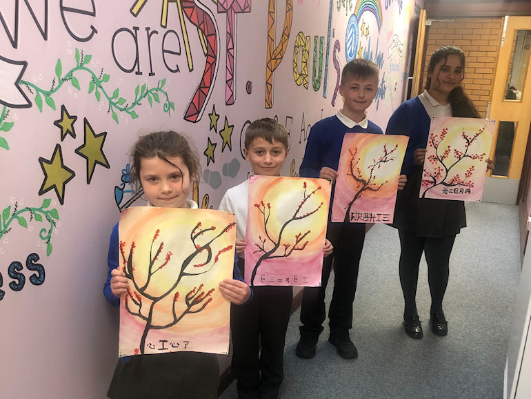 Four children displaying autumnal artwork