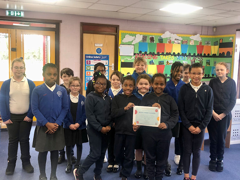 A group of children showing the school's Music Mark award